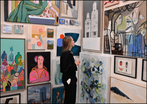 Woman standing and looking at paintings
