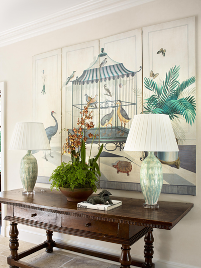 Entryway with paintings and lamps styled by Bunny Williams
